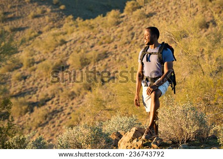 Young man hiking outdoors on a trail at Phoenix Sonoran Preserve in Phoenix, Arizona. Royalty-Free Stock Photo #236743792
