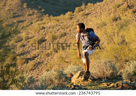Young man hiking outdoors on a trail at Phoenix Sonoran Preserve in Phoenix, Arizona. Royalty-Free Stock Photo #236743795