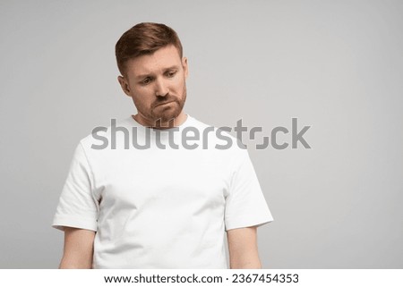 Sad disappointed man with head down on gray background. Portrait of young upset frustrated guy. Problems, depression, desperation, hopelessness, frustration concept. Negative human sincere emotions. Royalty-Free Stock Photo #2367454353