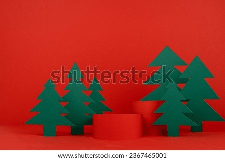 Festive Christmas stage with two red cylinder podiums mockup with green spruces as forest for presentation cosmetic products, gifts, advertising, design, copy space. New Year festive template.