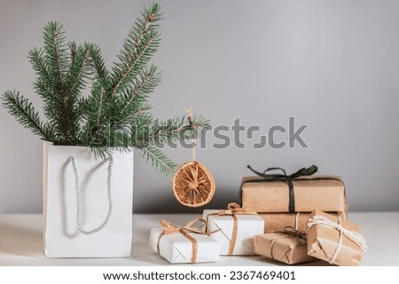 Fir branches decorated with dried orange slices, Christmas gift boxes in eco craft packaging. Natural materials and textures in Christmas decor, eco-Christmas holiday.