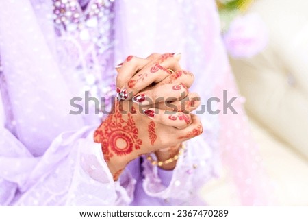 Jambi Indonesia; a woman who is holding her hands which are being hennaed