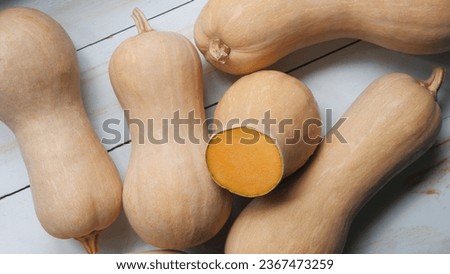 some butternut pumpkins (Cucurbita moschata) on a white wooden table Royalty-Free Stock Photo #2367473259