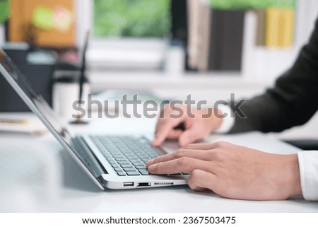 Businessman hand working on laptop for new architectural project. Generic design notebook on the table. Blurred background, horizontal mockup.