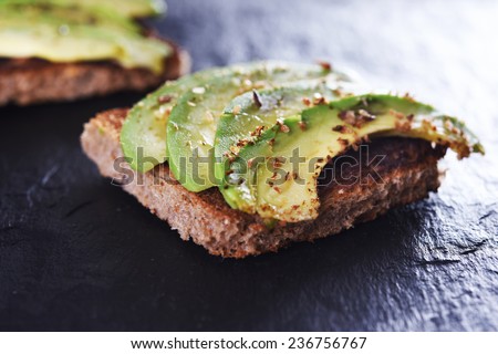 sliced avocado on toast bread with spices Royalty-Free Stock Photo #236756767