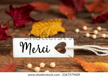 Autumn or Fall Background with Label with French Text Merci, Means Thank You in English, Colorful Autumn Leaves, Seasonal Background with Quote