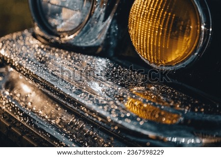 A closeup of car bumper with rain drops