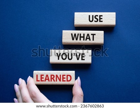 Use what You have learned symbol. Wooden blocks with words Use what You have learned. Businessman hand. Beautiful deep blue background. Business and Use what You have learned concept. Copy space.