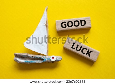 Good luck symbol. Wooden blocks with words Good luck. Beautiful yellow background with boat. Business and Good luck concept. Copy space.