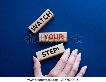Watch your Step symbol. Concept words Watch your Step on wooden blocks. Businessman hand. Beautiful deep blue background. Business and Watch your Step concept. Copy space.