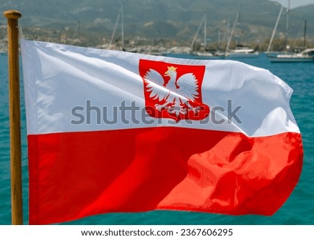 The state flag of Poland on the background of yachts at the anchorage.