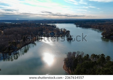 a stunning aerial shot of the Catawba River surrounded by vast miles of green and autumn colored trees with blue sky and clouds in Charlotte North Carolina USA