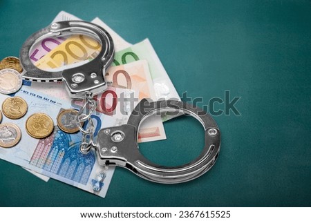 Police handcuffs and money bill pile