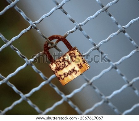 Old and new locks with names and dates written on them from many couples soul connection in love lock on a bridge as a sign of love in Dorsten Germany close up high quality instant print