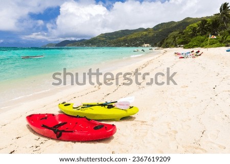 Seychelles beach view. Colorful plastic kayaks lay on white sand on a sunny day Royalty-Free Stock Photo #2367619209