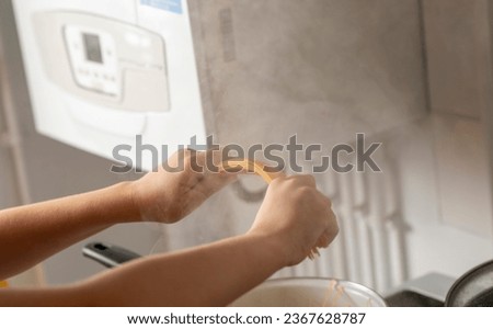 children's hands holding spaghetti near a pot of boiling water in the kitchen natural shot