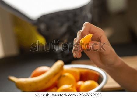 female hands peeling a tangerine over the table