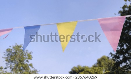 Colorful party flags bunting hanging on blue sky for holiday decoration