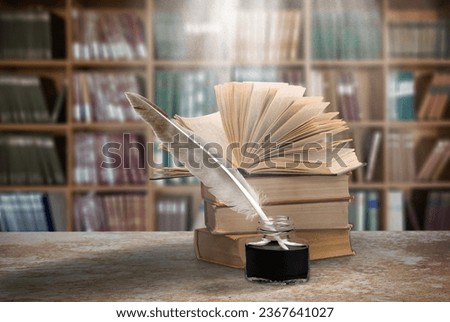 Old books and retro quill pen on desk in library. Royalty-Free Stock Photo #2367641027