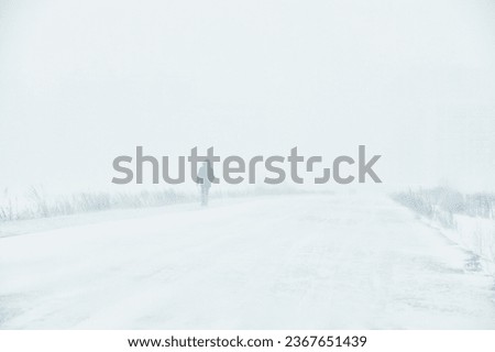A snowstorm. People walk down the street during a snowstorm. Heavy snowfall.  against the background of a cold urban landscape Royalty-Free Stock Photo #2367651439