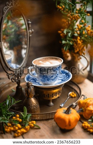 cup of cappuccino in still life. mirror behind the cup. beautiful picture. vintage autumn still life.