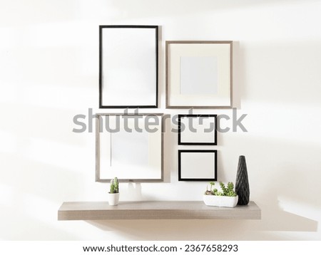 Gallery Set Mock-Up of Blank Picture Frames and Grey Floating Shelf with Plant Pot Ornaments, Featuring Wooden Frame Set Hanging on a White Wall.