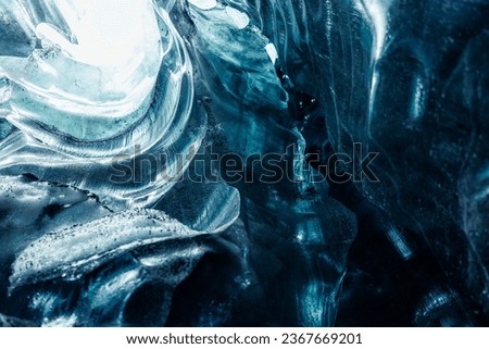 Majestic blue ice formations inside cave glowing covered in frost, transparent icy blocks in vatnajokull glacier crevasse. Glacial iceberg rocks forming natural winter setting in iceland. Royalty-Free Stock Photo #2367669201
