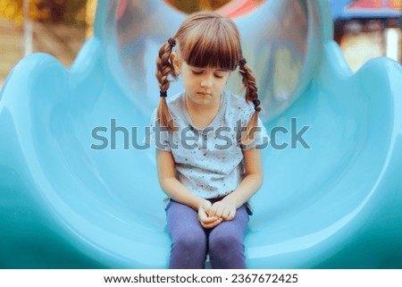 
Sad Little Girl Sitting Alone in a Playground Slide. Timid anxious single child having none to play with
 Royalty-Free Stock Photo #2367672425