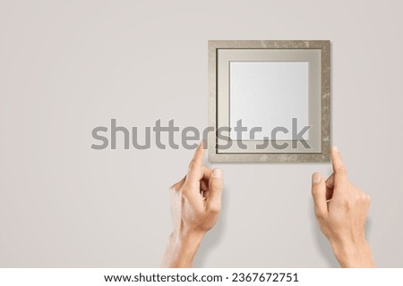 Woman hands hanging wooden frame