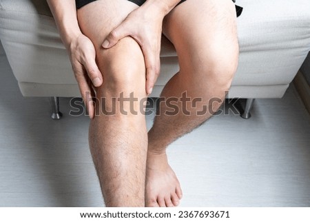 Man with knee pain, he puts his hand on his knee, pain point from osteoarthritis and osteoarthritis, medical concept and treatment Royalty-Free Stock Photo #2367693671
