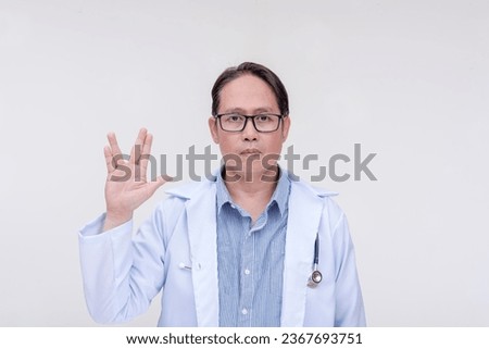 A trekkie fan and doctor makes the vulcan live long and prosper sign. Of asian descent, middle aged male in his 40s. Isolated on a white background.