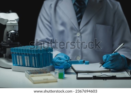 medical research laboratory Asian male scientist working using digital tablet analyze the sample record biochemical data medical science laboratory development of microbiology advanced equipment.