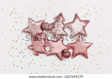 Christmas square pattern with shining pink color toys in shape Christmas fir tree and star with sequins, small xmas ball, monochrome card. New Year holiday composition, shiny trend holiday background