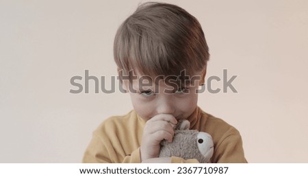Portrait of a little boy with a soft toy in his hands. Shooting in the studio