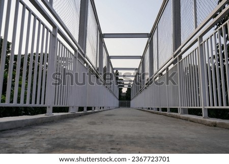 a bridge crossing, with an iron fence painted white, the background of the sky in the morning. 