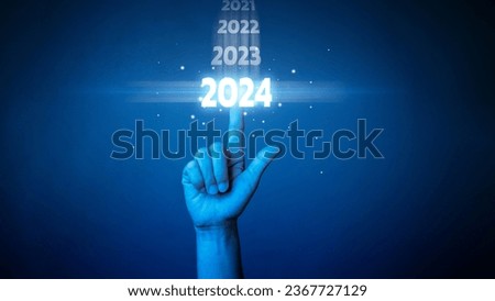 Hand touch on download bar status to change from 2023 to 2024 to countdown Merry Christmas and Happy New Year with technology concept. Starting a new business on a dark background