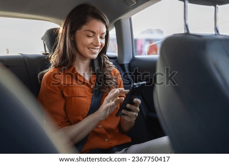 Successful young businesswoman in office clothes working using smart phone in sitting back seat of car in urban modern city in night. People occupational burnout syndrome concept. Royalty-Free Stock Photo #2367750417