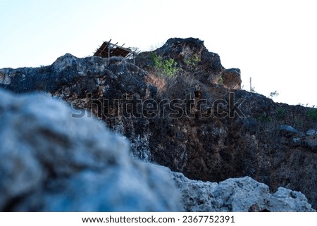a geribik building on top of a limestone hill in the Beko Hills .Hut on Top of a Rocky Cliff. Limestone mining on Mount Beko