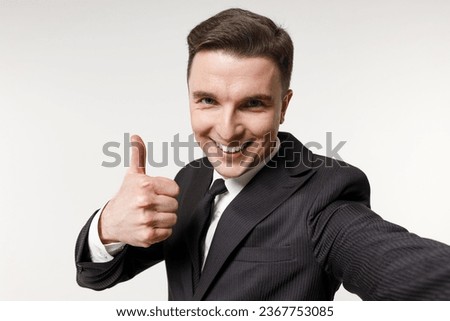 Close up young employee business corporate lawyer man in classic formal black grey suit shirt tie work in office do selfie shot mobile phone show thumb up gesture isolated on white background studio