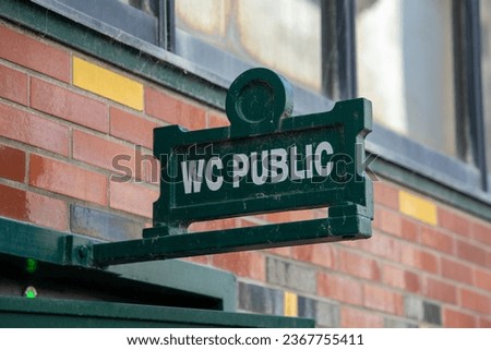 vintage retro sign indicating public toilets Restroom wc text in city street