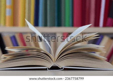 open book and hardback books on wooden table background. back to school. copy space