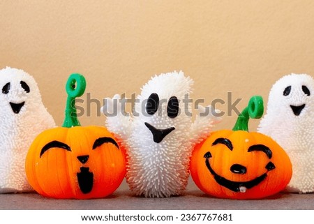 Pumpkins and ghosts celebrating trick or treat on Halloween day. Smiling orange Jack-O'-Lantern. 
