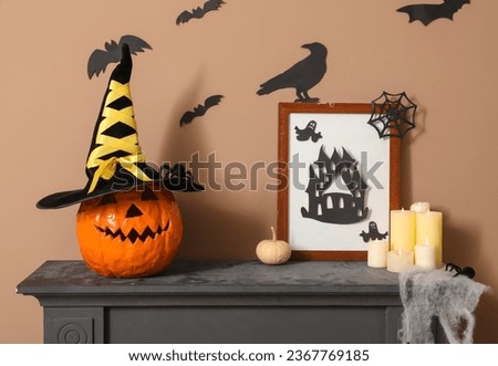Mantelpiece with Halloween decor and burning candles in room