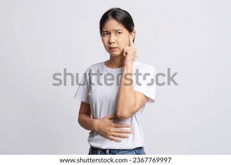 Asian woman has an earache. She uses her hand to touch her ear. Otitis media or tinnitus concept. Royalty-Free Stock Photo #2367769997