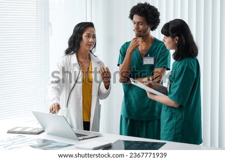 Doctor explaining nurses how to fill forms with results with xray analysis