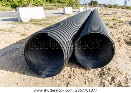 Polyvinyl chloride Drainage Pipe on a Construction Site. Polyvinyl chloride drainage pipes stacked for construction. Polyvinyl chloride drainage tube on construction site near high way road	