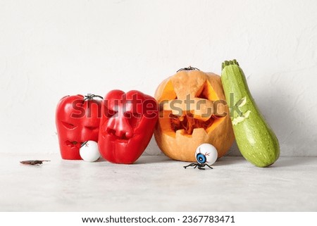 Carved vegetables for Halloween with spiders and eyes on white background