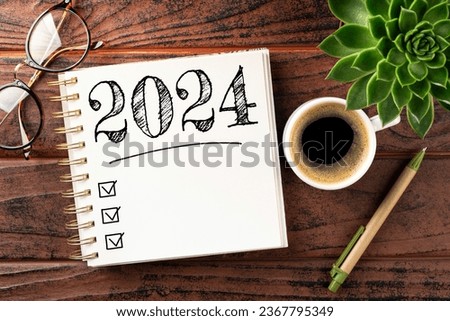 New year resolutions 2024 on desk. 2024 goals list with notebook, coffee cup, plant on wooden table. Resolutions, plan, goals, action, checklist, idea concept. New Year 2024 resolutions. Copy space Royalty-Free Stock Photo #2367795349