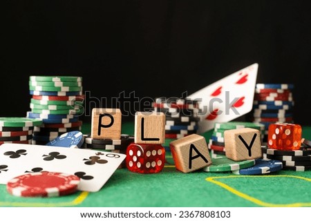 The word play on wooden cubes, poker chips with playing cards on the green casino table. gamble