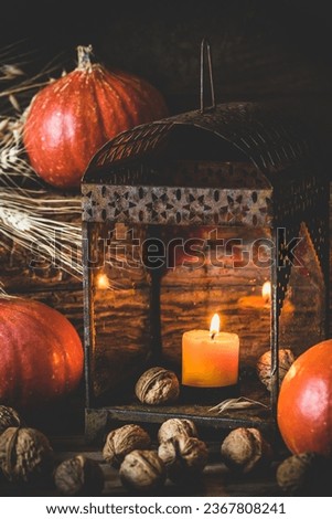 Orange pumpkins, lantern and walnuts on rustic wooden background, autumn decoration, vertical  Royalty-Free Stock Photo #2367808241